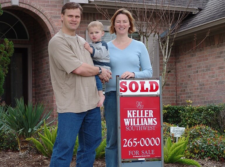 Photo of a family infront of a Fort Bend area home with a sold real estate sign